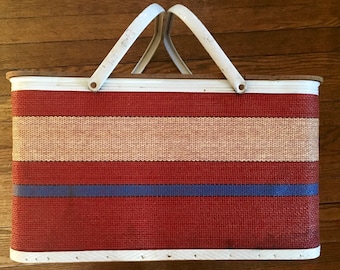 Vintage circa 1960s Redmon Picnic Basket. Red, blue and cream striped woven design. White metal trim and double handles, with dishes