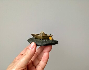 Paperboat brass sculpture, tiny brass sculpture of paperboat with tiny eye charm, paperboat sculpture on black stone, brass boat gift
