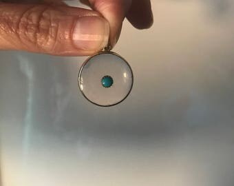 A crystal locket set to the centre with a turquoise
