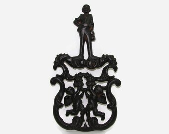 1955 J.Z.H. Cast Iron Trivet, Cupid and Gentleman, J Z H Cherubs Black Metal Trivet, JZH T-11