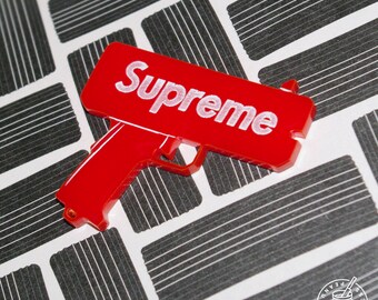 Supreme - Cash Cannon Money Gun pin badge, magnet