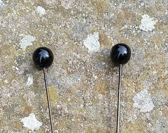 Large black glass topped edwardian hat pins.