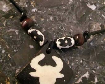 Chain of leather with a pendant of bone with the image of a ossekop, bullshead, skull, skull.