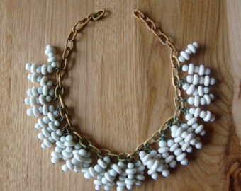 Very vintage white glass beads wired to celluloid chain in very beautiful vintage condition and ready for your summer wardrobe .