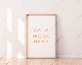 Vertical Poster with Wooden Frame Mockup standing on the floor in light interior / Blank canvas