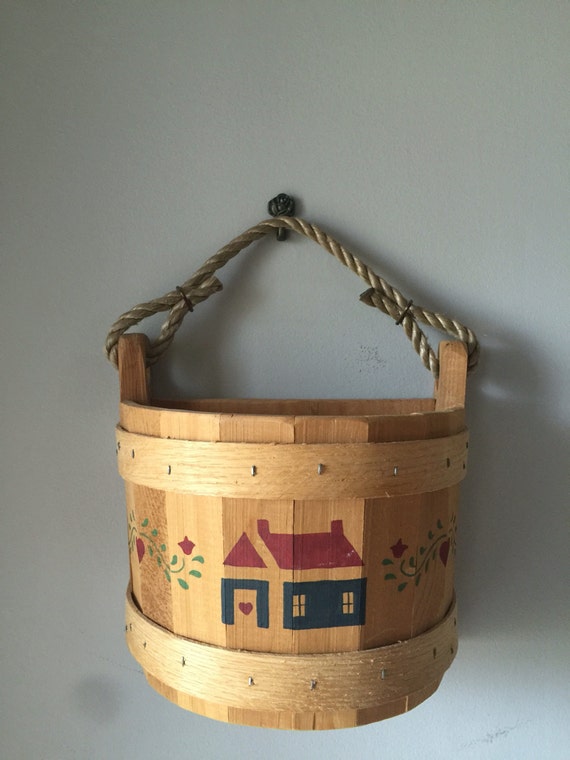 vintage bucket with rope handle. Hangs on wall.