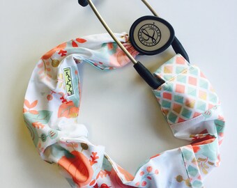 Stethoscope cover featuring a peach teal and gold floral pattern