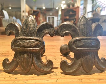A pair of fleur de lis cutain tie backs