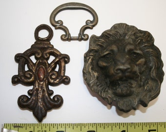 Three old brass (?) pieces for crafting: Lion belt buckle; A-C drawer pull; mystery drop/shade pull?