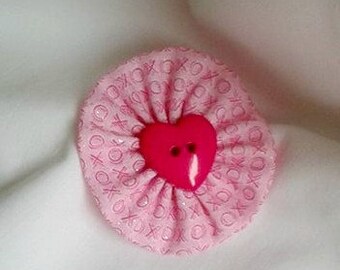 XO Hand-stitched yo yo hair clip with a red heart.