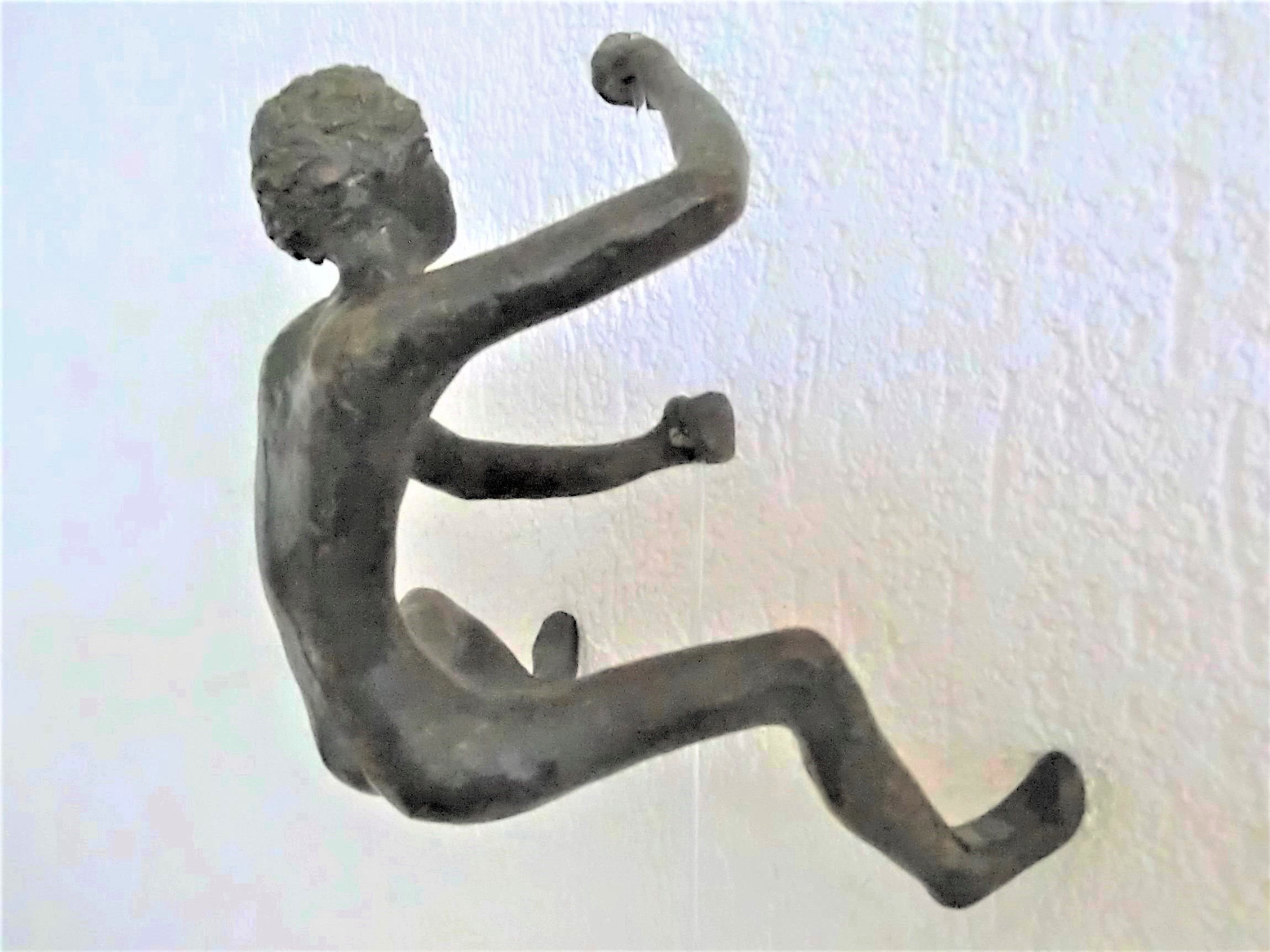 JONGEN/ hangend bronzen figuur/ klimmend tegen de muur/ bruin