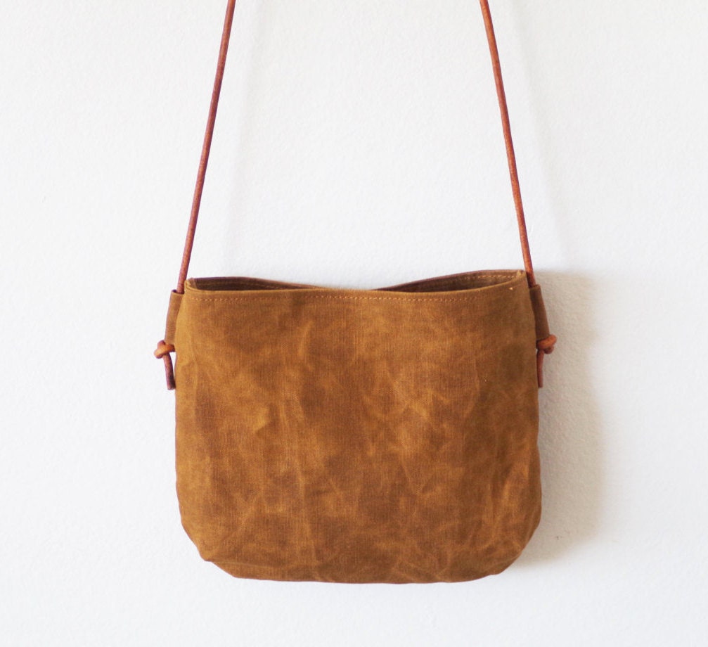 Small brown waxed canvas crossbody bag with round leather