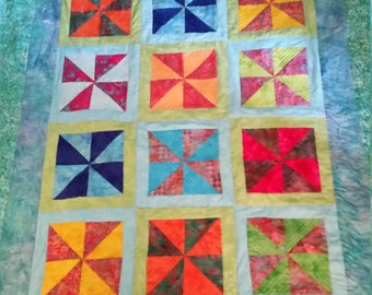 Twin sized bright batik quilt in windmill pattern