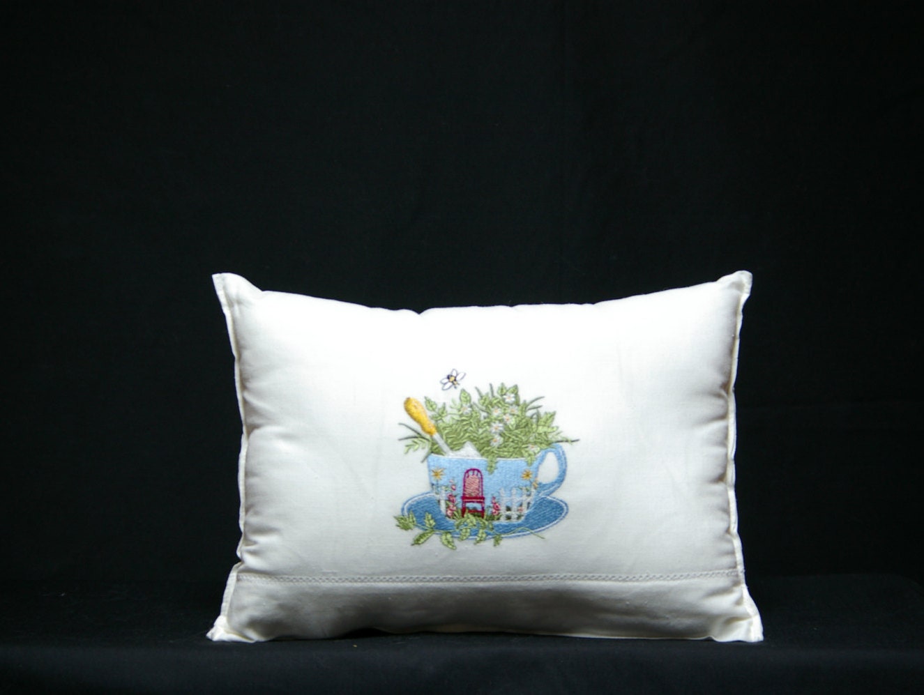 Tea Cup and Saucer Pillow features charming embroidery in