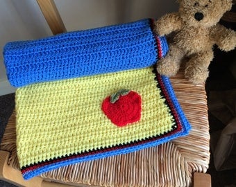 Handmade crochet baby blanket inspired by Snow White with bow and apple detail. Approximately 26 x 24 inches.