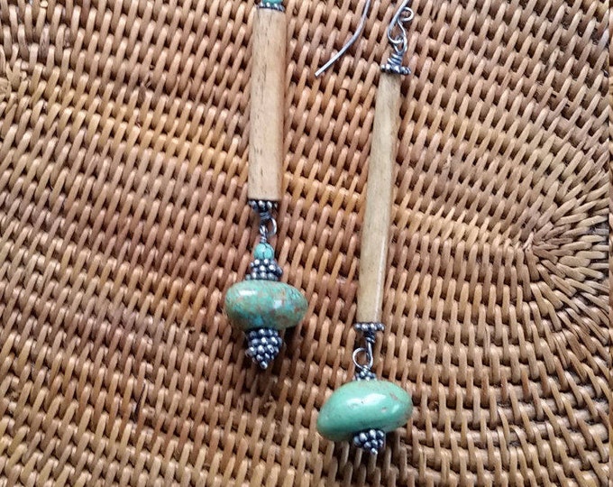 These Asymmetrical Earrings are made of Bone, Sterling Silver, And Turquoise