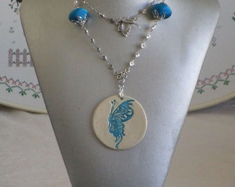Ravissant collier pendentif en céramique et métal argenté avec perles et pompons en soie "Papillon"