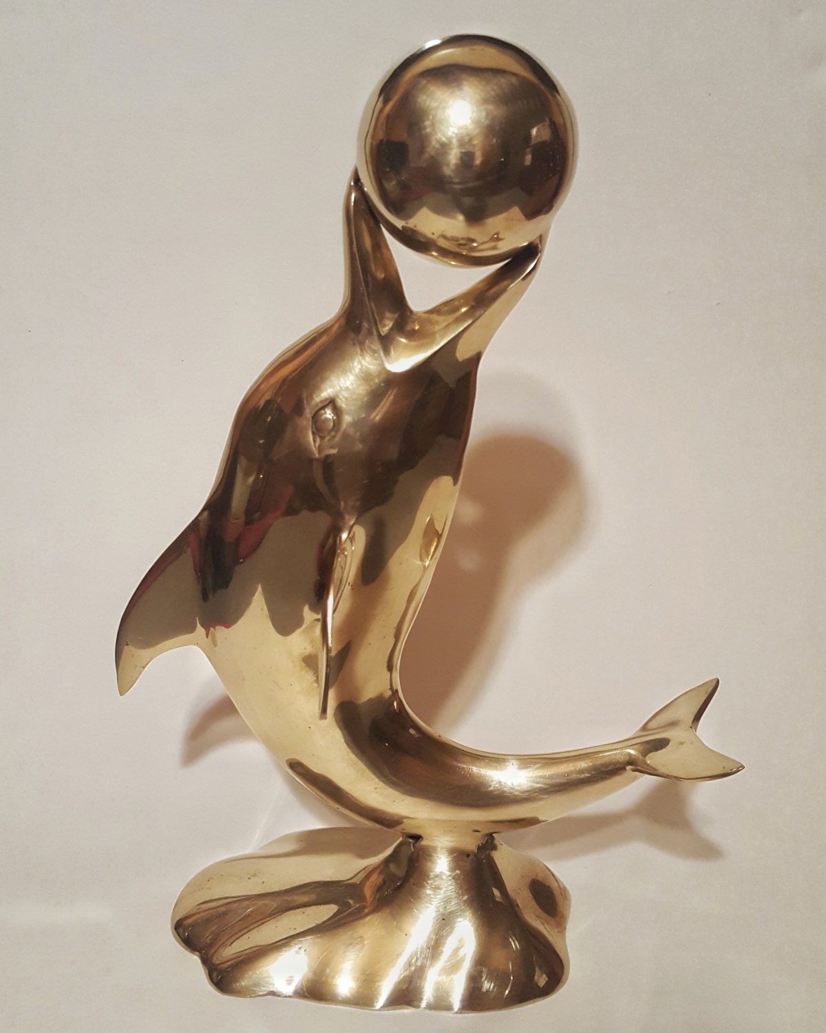 large brass dolphin statue