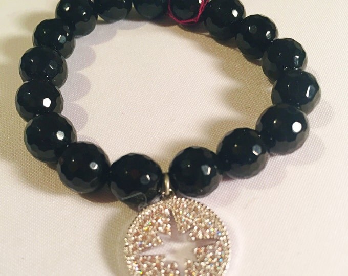 Glamorous trendsetting faceted black onyx agate beaded stretch bracelet with a crystal starburst charm.
