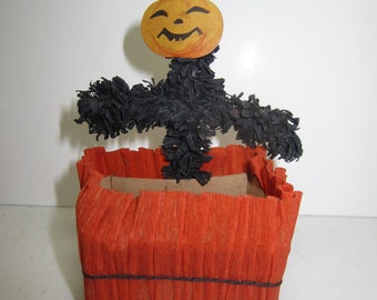 1920's Halloween crepe paper nut cup in orange with black fringed crepe paper scarecrow body with die cut jack o lantern face