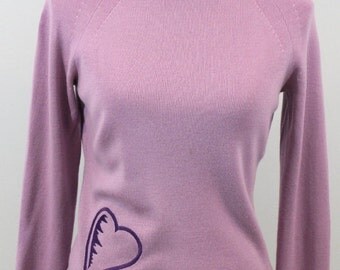 Pale violet merino wool blend turtleneck sweater with embroidered heart struck design.
