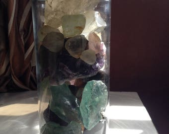 A jar of different types of raw gem stones