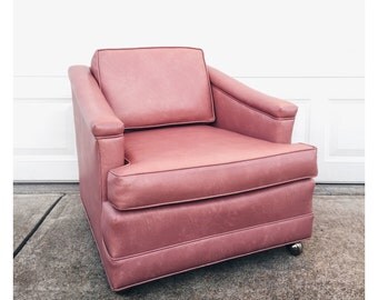 Mid century pink vinyl lounge chair on casters, vintage pink chair, low pink lounge chair