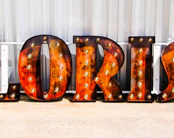Any 7 Marquee letter sign with globe bulbs, single sign bracket, in the font and finish of your choice. UL listed sockets weatherproof