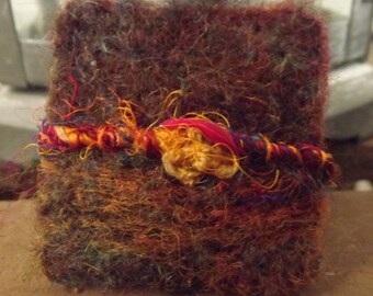 Pretty needle felted brooch created using natural wool and sari silk inspired by summer meadows