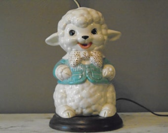 Retro child's / infant's large ceramic dresser lamp with a white lamb in blue coat and polka dot bow tie on a brown faux wood base