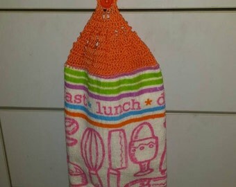 Kitchen tea towel with crocheted top and kitchen utensils print reads" breakfast lunch dinner "
