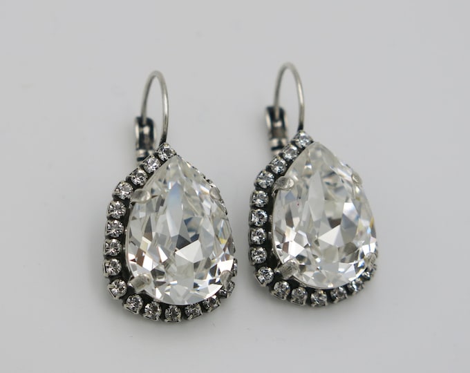 Eye-catching, bold large statement bridal wedding day Swarovski crystal pear-shape drop earrings embellished with a halo of sparkling pavé.