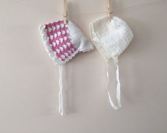 2 white and pink baby bonnets