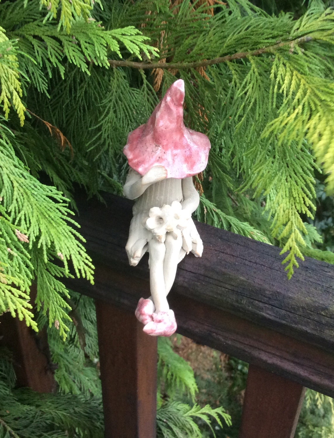 Shy fairy fairy garden pixie holding a posy of flowers.