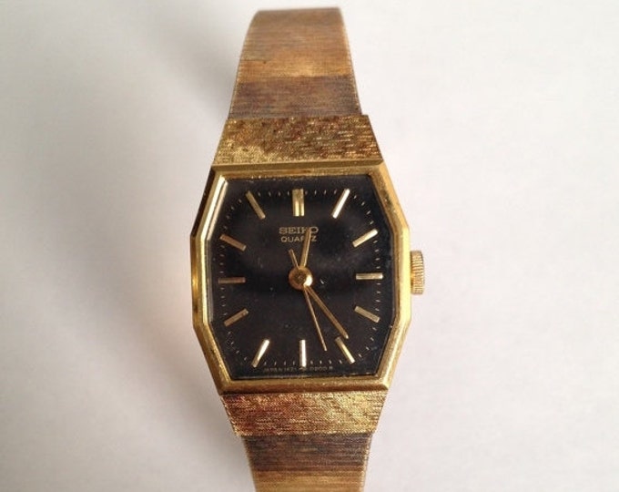 Storewide 25% Off SALE Vintage Ladies Antiqued Gold Tone Black Faced Quartz Seiko Watch Featuring Omega Style Bracelet Band And Safety Chain