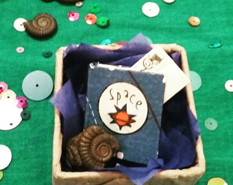 Minature space book. Contains ammonite fossil.