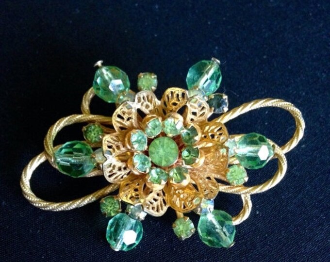 Storewide 25% Off SALE Vintage Oversized Gold Tone Circular Floral Style Ladies Brooch Featuring Faceted Emerald Green Rhinestone Accents.