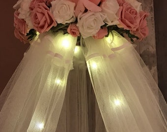 Soft pink and white crib canopy with fairy lights and flowers
