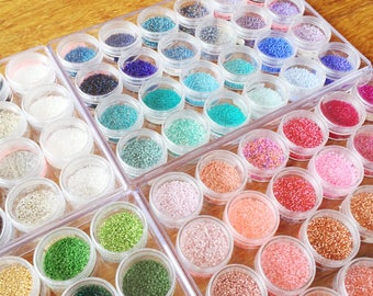 Beads storage system for Miyuki delicas with 24 circular clear plastic jars in a rectangular clear plastic box