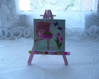 A frame with a fairy, tulips and butterflies on her easel for a girl