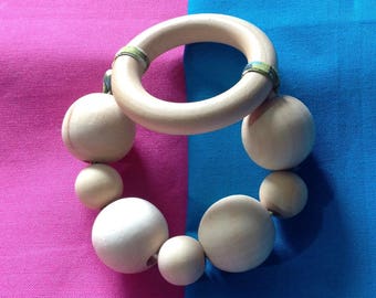 Wooden rattle and teether in her pouch.