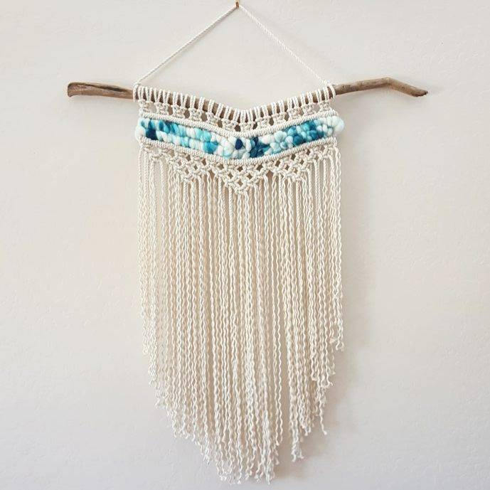 Large macramé wall hanging on driftwood.