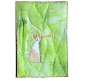 Trumpet angel on green fabric postcard