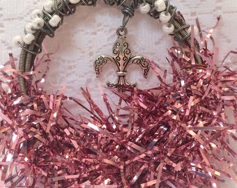 Christmas ornament, made of guitar strings glass beads, pink Garland, and a fleur-de-lis