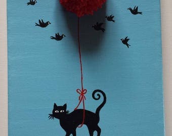 A black cat flies hanging from a red balloon