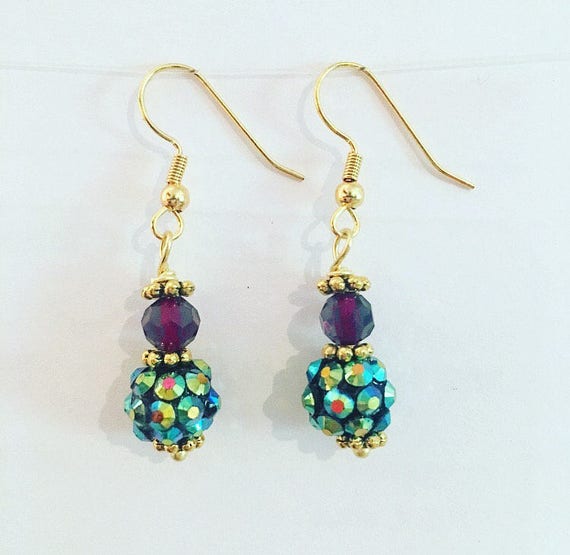 Items similar to Peacock dangle earring gold plum glass green faceted ...