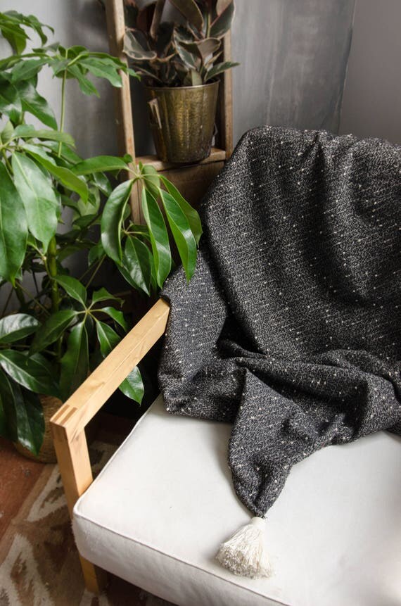 Black and white throw blanket with white tassels.