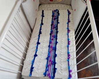 Blanket, plaid, top of cradle.