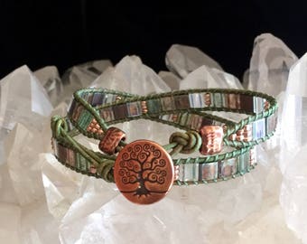 Flat wrap, green leather, shades of green Miyuki Tila beads, copper seed beads, copper Tree of Life button