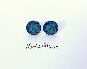 Earrings made of plastic crazy blue and green flower on black background